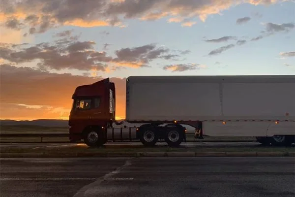 SHACMAN X5000 6x4 tractor truck with semitrailer at sunset